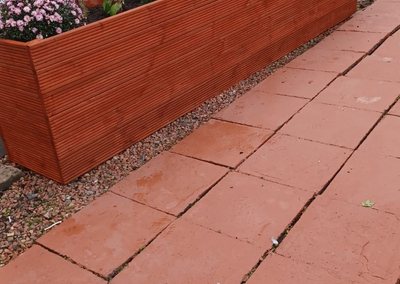 Long stained timber planter along the front of a house